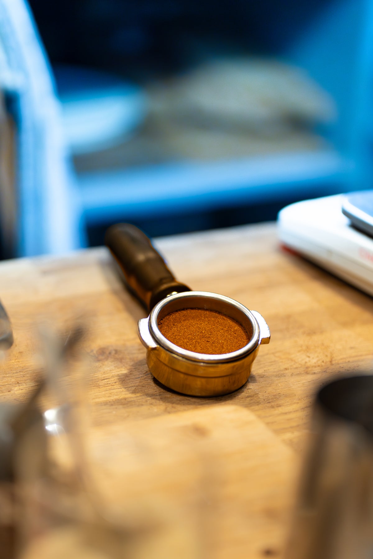 Close-up of a level, tamped espresso puck in a portafilter resting on the café counter.